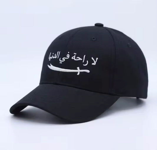 Premium Arabic embroidery cap with La Raha Fi Dunya calligraphy in white embroidery on a black structured ottoman fabric base.