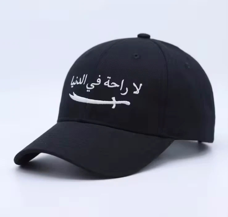 Premium Arabic embroidery cap with La Raha Fi Dunya calligraphy in white embroidery on a black structured ottoman fabric base.