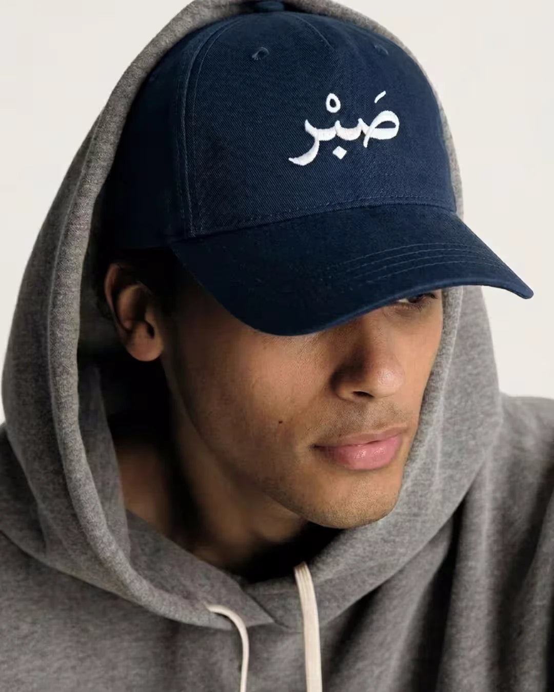 Man wearing navy Sabr cap - Islamic cap for men streetwear style