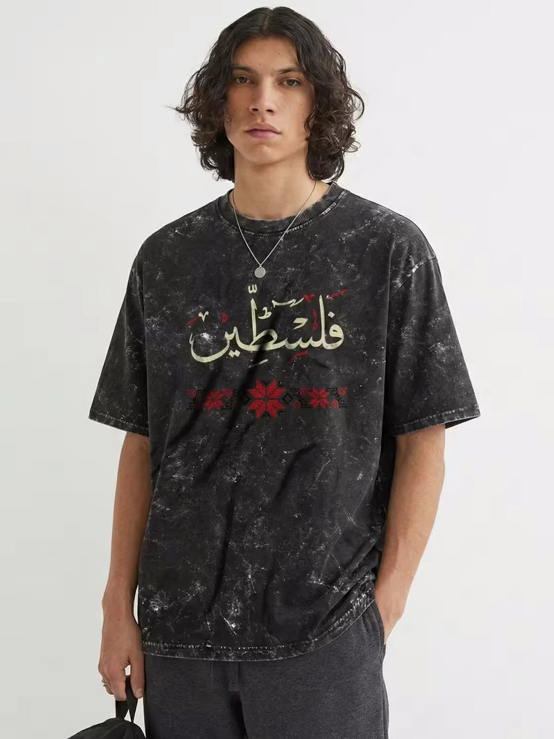 Palestine T Shirt black acid wash with Arabic calligraphy فلسطين and red tatreez motifs on white background by Zaroodi