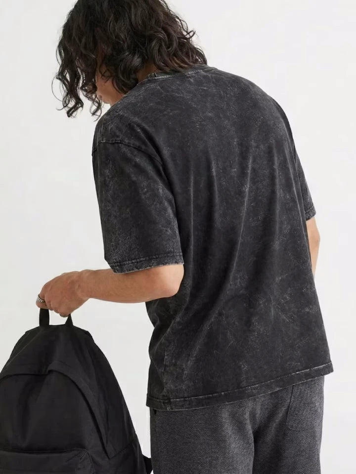 Editorial streetwear shot of Palestine T-shirt showing Arabic calligraphy فلسطين and tatreez border print on acid washed black oversized tee by Zaroodi