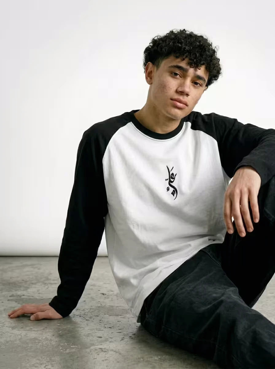 Editorial streetwear pose wearing NISQ MUNQASAM Ali raglan by Zaroodi