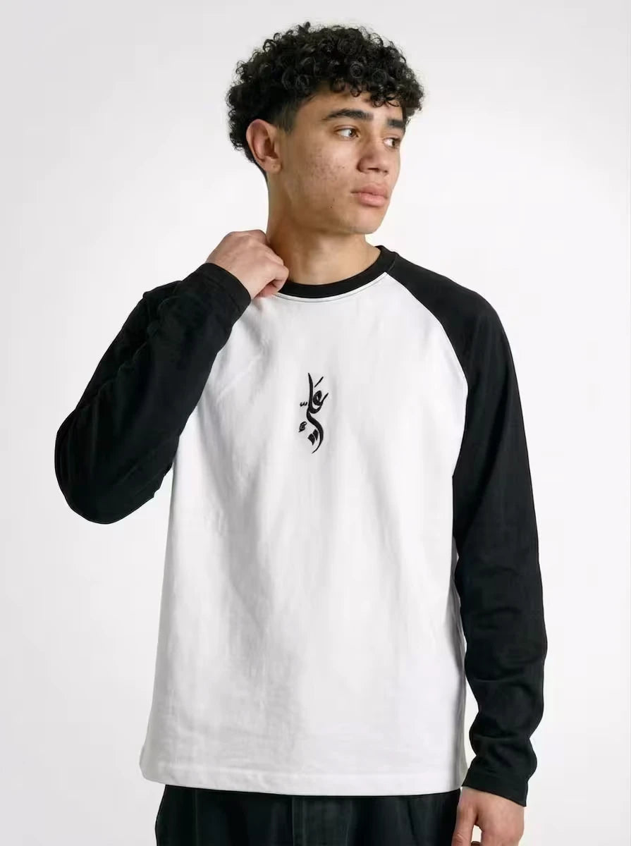 Model wearing NISQ MUNQASAM Ali embroidered black and white raglan t-shirt by Zaroodi