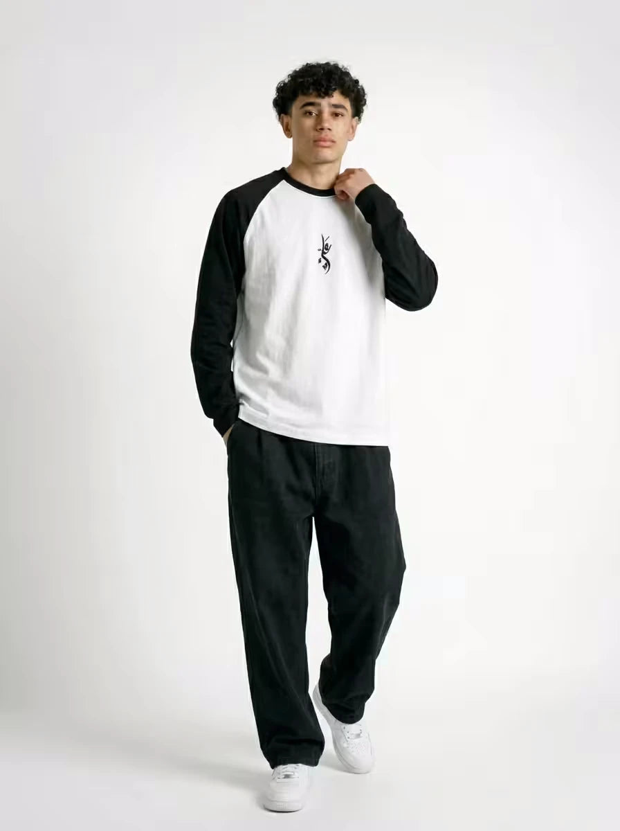 Full body fit of NISQ MUNQASAM Ali raglan t-shirt styled with wide black denim